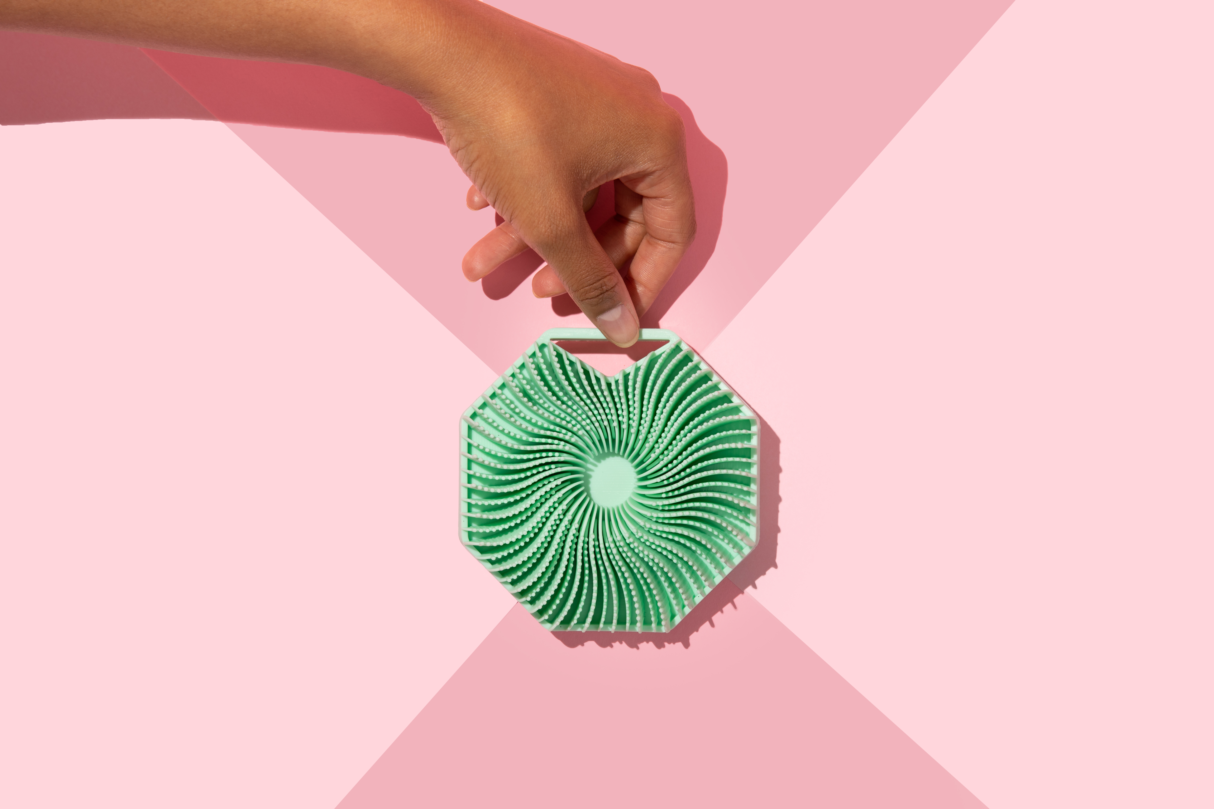 hand holding Sud Scrub Body Scrubber