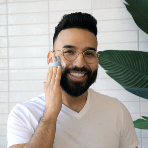 man using Sud Scrub face scrubber on face