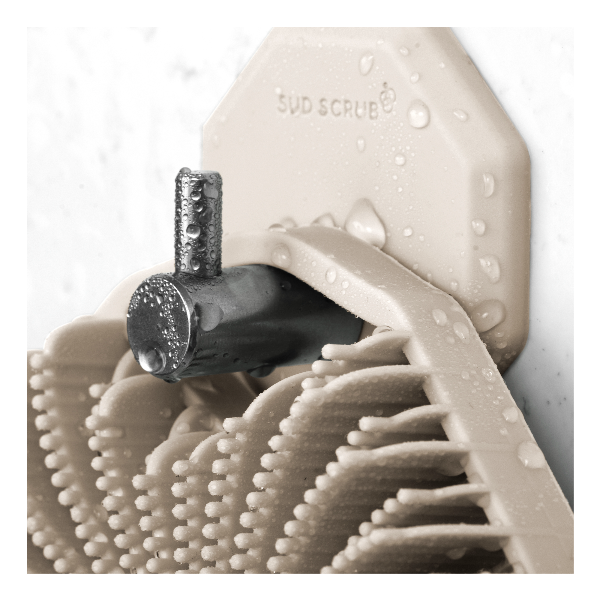 Up close shot of clay Sud Scrub Shower Hook and a Clay Sud Scrub Body Scrubber hanging onto it.