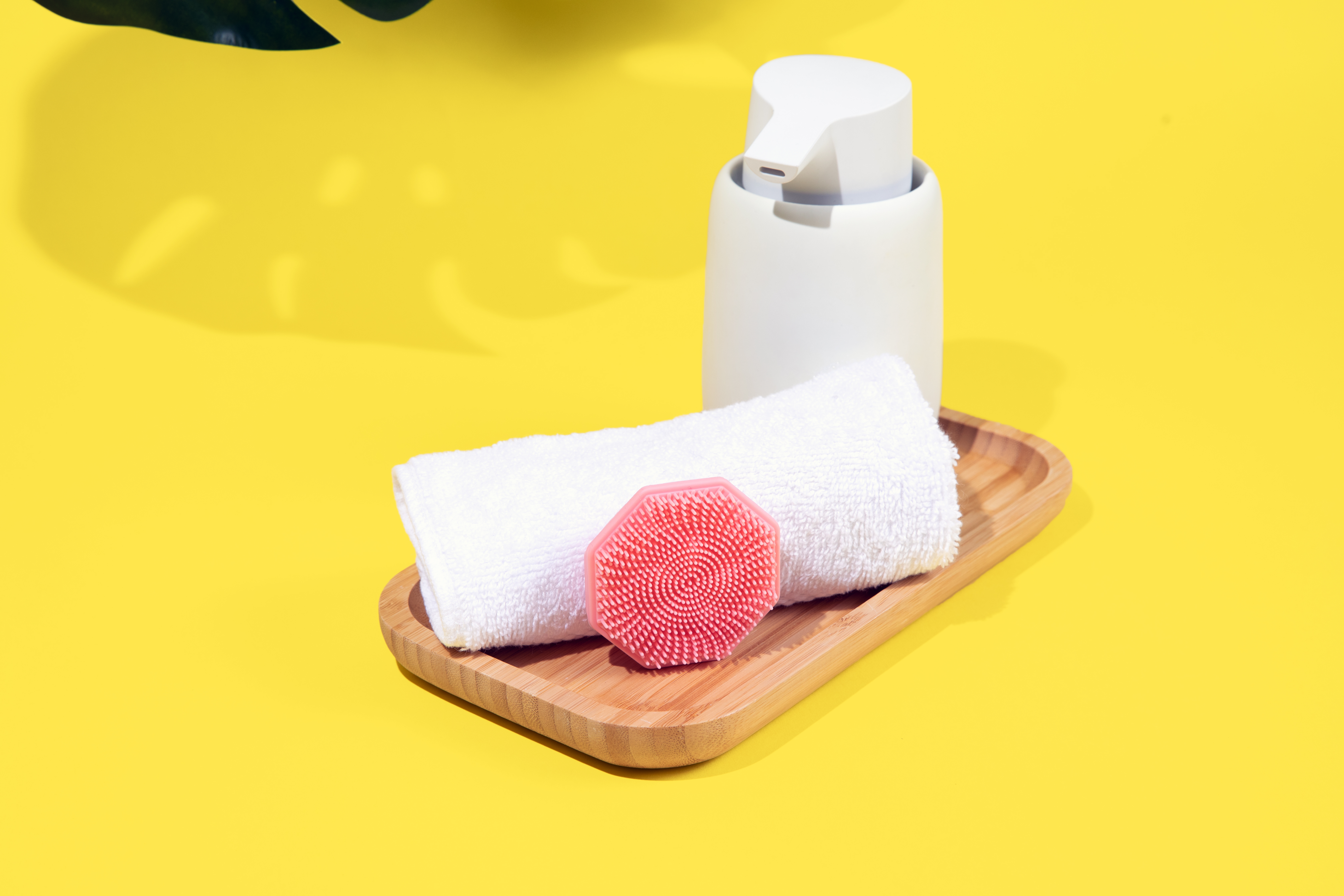 Sud Scrub face scrubber leaning against a towel in a bathroom setting
