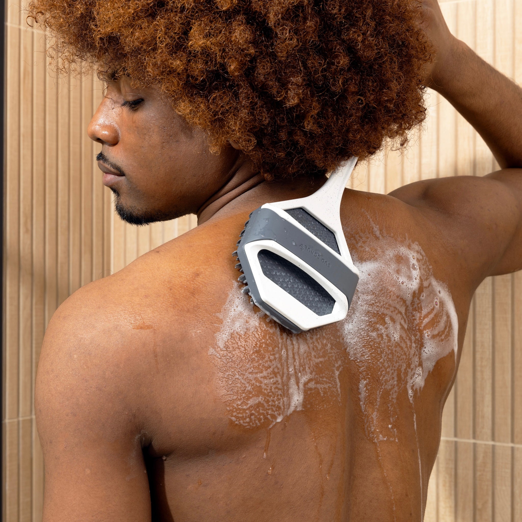 Man using Sud Scrub extender handle on back