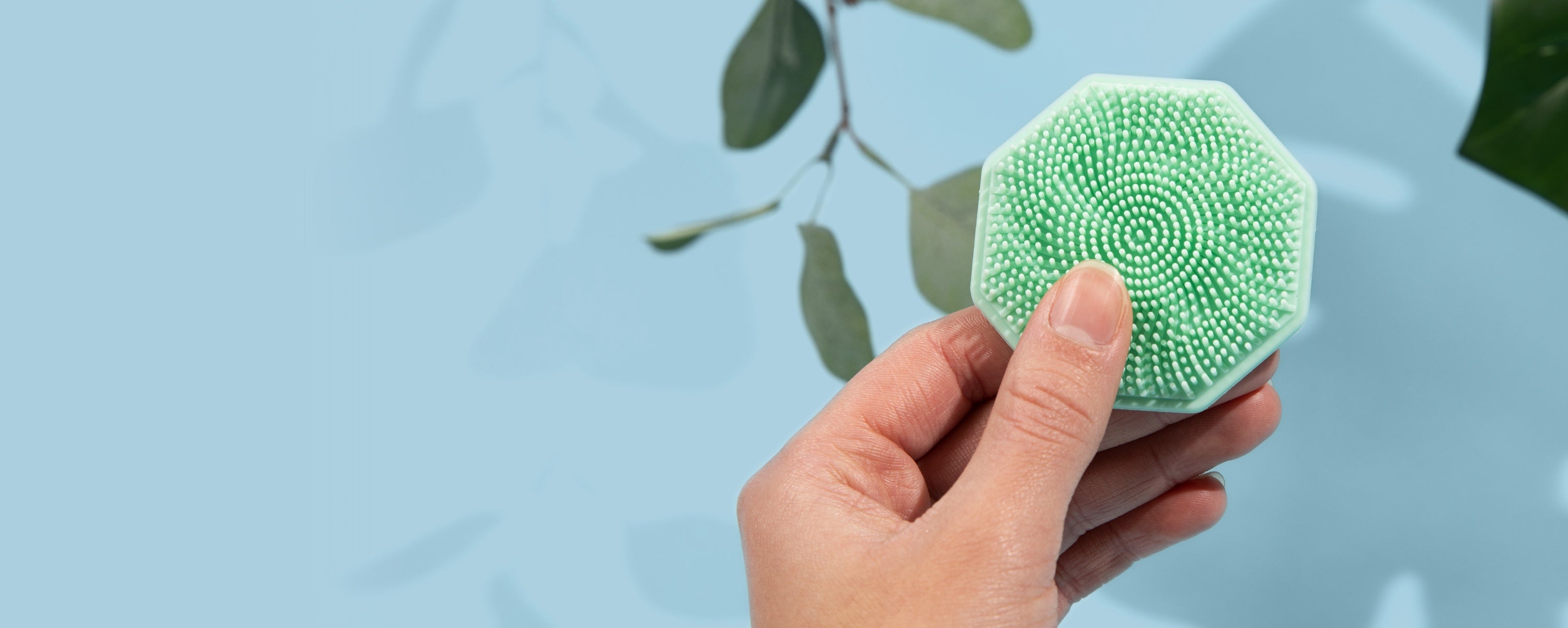 hand holding Mint Sud Scrub Face Scrubber