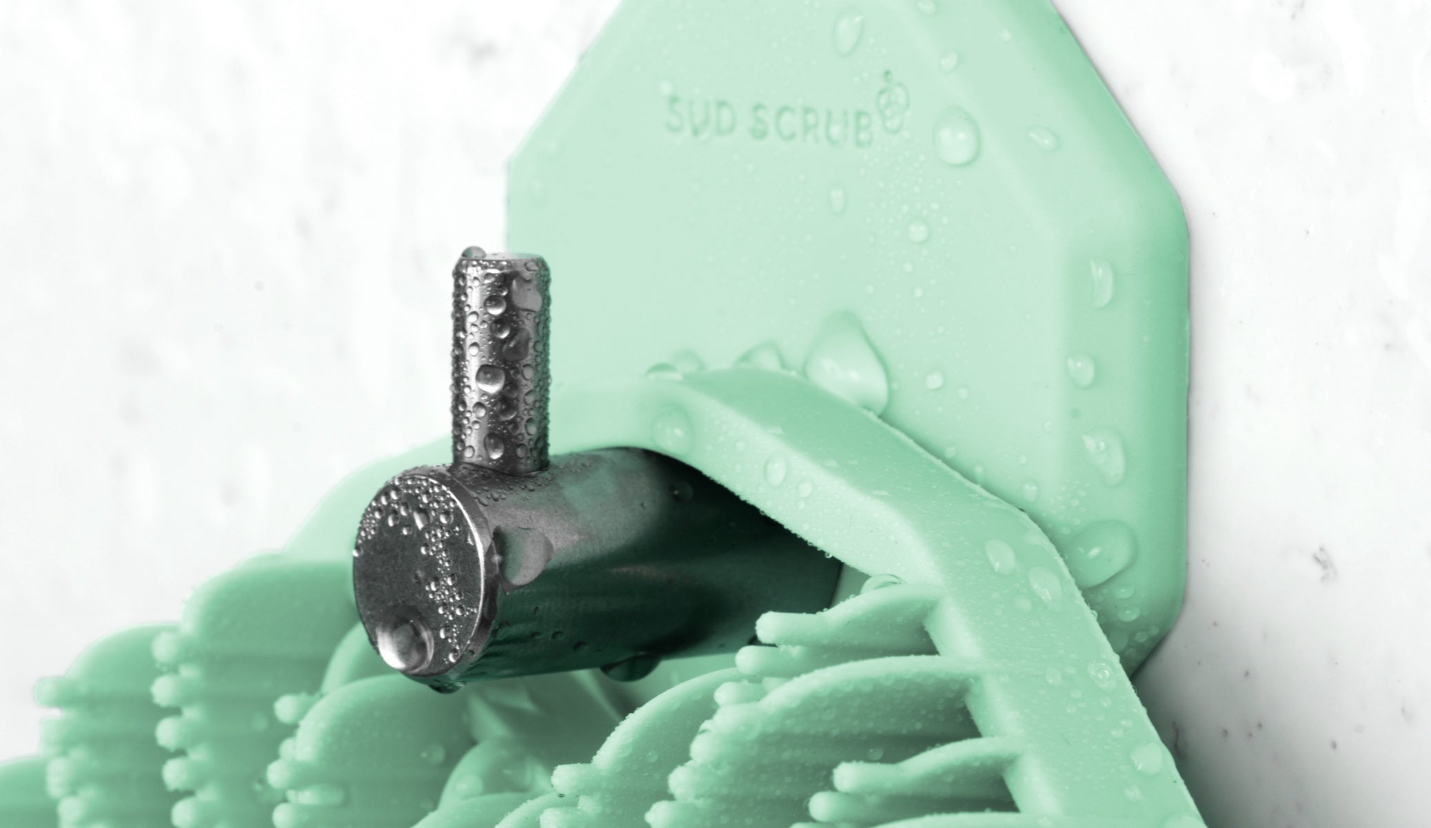 Up close detailed shot of Mint Sud Scrub Body Scrubber hanging on the mint Sud Scrub Shower Hook in the shower.