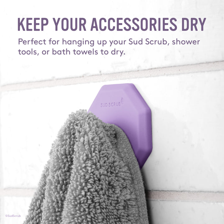 Keep your accessories dry. Purple Sud Scrub Shower Hook holding up a grey towel.